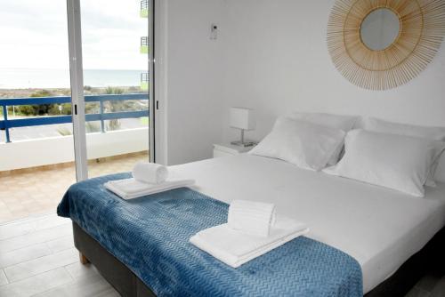 a bedroom with a bed with a view of the ocean at Casa Azul in Monte Gordo