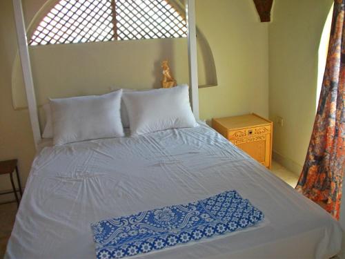 a bedroom with a white bed with a window at Farida Apartments in Luxor