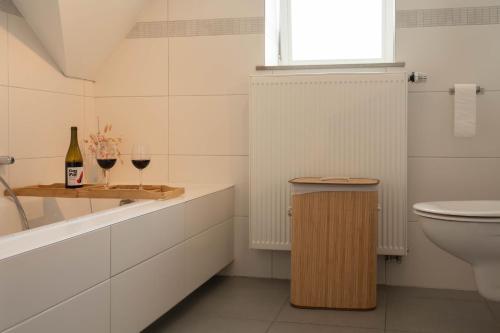 een badkamer met een toilet en 2 glazen wijn bij Huize Nassau in Zelem