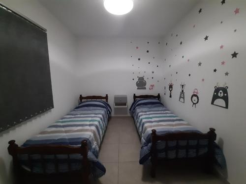 2 camas en una habitación con una pizarra en la pared en Alba Mendoza en Mendoza