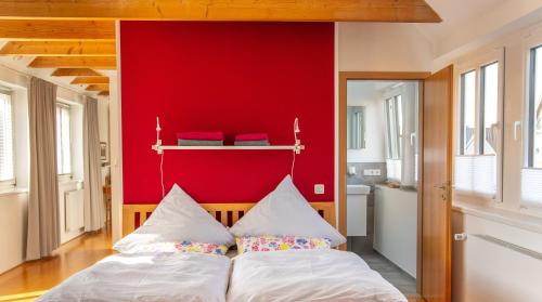 ein Schlafzimmer mit einer roten Wand und einem Bett in der Unterkunft Apartment Haak in Halle Westfalen