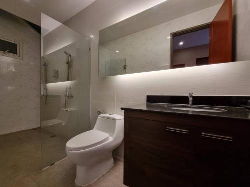 a bathroom with a toilet and a sink and a mirror at SilverGold PoolVilla in Jomtien Beach