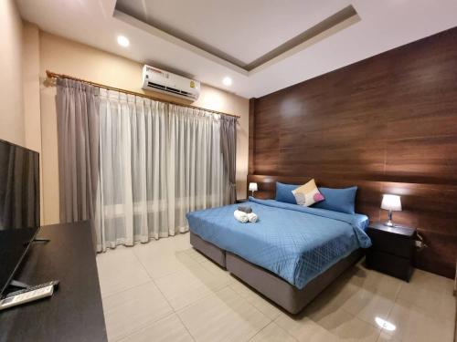 a bedroom with a bed with a blue bedspread at SilverGold PoolVilla in Jomtien Beach
