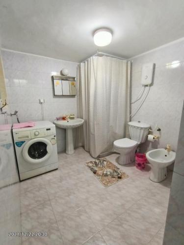 a bathroom with a washing machine and a toilet at Isaac's Home in Beit Sahour