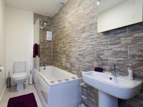 a bathroom with a sink and a tub and a toilet at Nazarene apartments in Leeds in Stanningley