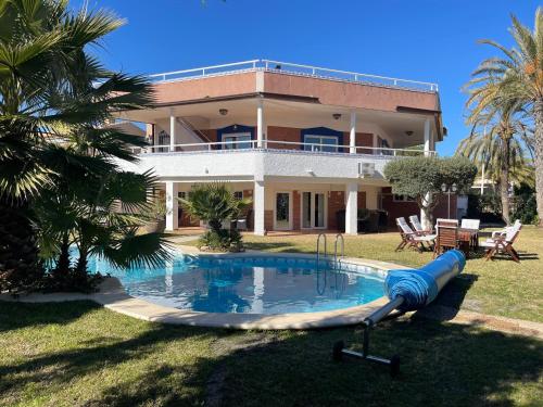 uma casa grande com uma piscina em frente em Anna's garden em Torrevieja