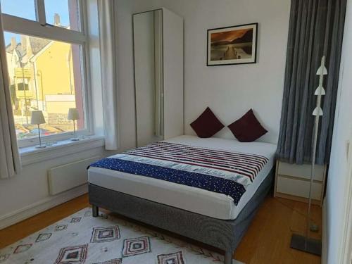 a bedroom with a bed in front of a window at Cozy, Central, Ocean View in Ålesund