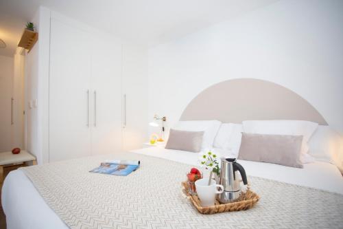 a bedroom with a white bed with a tray with flowers at SingularStays Arena in Valencia