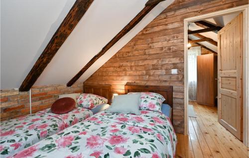 2 Bedroom Cozy Home In Hrastovica : غرفة نوم بسرير وجدار خشبي