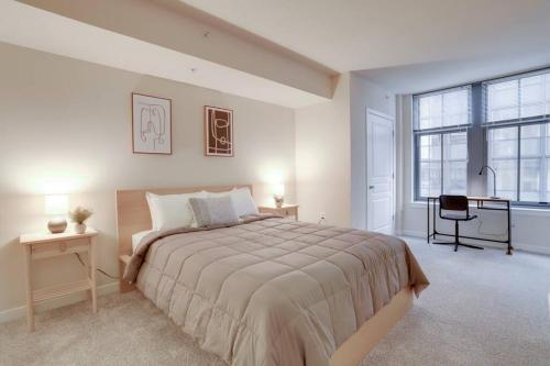 a white bedroom with a large bed and a desk at Wonderful 2 BR Condo At Pentagon City with Gym in Arlington