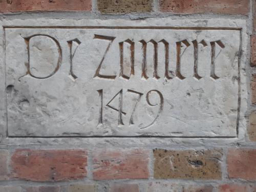 een stenen bord aan de zijkant van een stenen muur bij De Zomere B&B in Brugge