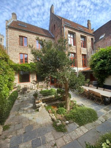 a large brick building with a tree in the courtyard at De Zomere B&B in Bruges