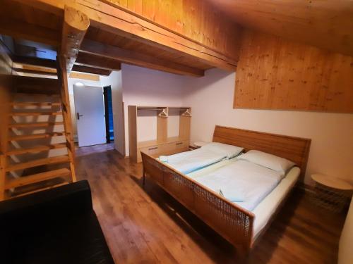 una camera con letto in una stanza con soffitti in legno di Chata Resort Na Horské a Malá Morávka