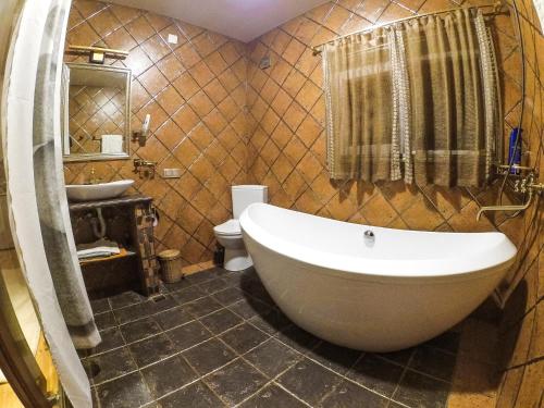 a bathroom with a tub and a toilet and a sink at Batumi Wonderland in Batumi
