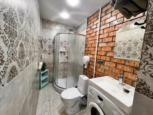 a bathroom with a shower and a toilet and a sink at Sport Hotel Terra in Ustʼ-Kamenogorsk