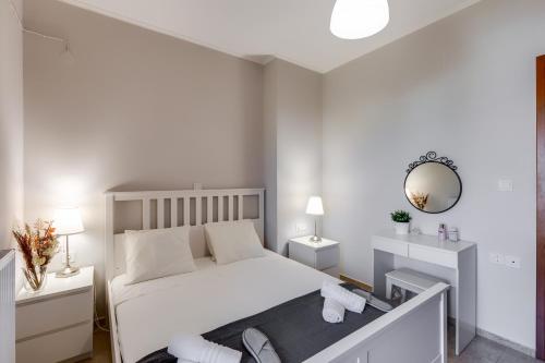 1 dormitorio con cama blanca y espejo en Stema City Apartment, en La Canea
