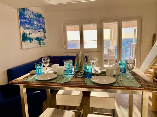a dining room table with plates and glasses on it at Tanis Ocean Loft in Martinšćica