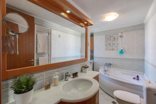 y baño con lavabo, bañera y espejo. en Stema City Apartment en La Canea