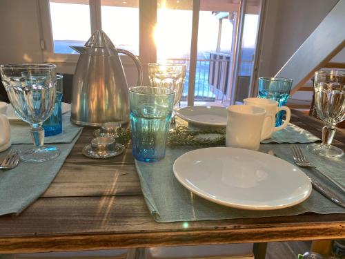 a wooden table with plates and glasses on it at Tanis Ocean Loft in Martinšćica