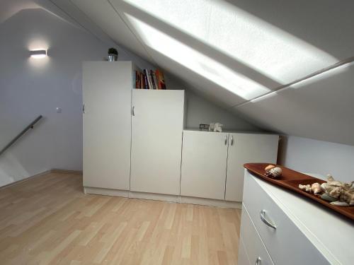 a attic kitchen with white cabinets and a skylight at Tanis Ocean Loft in Martinšćica