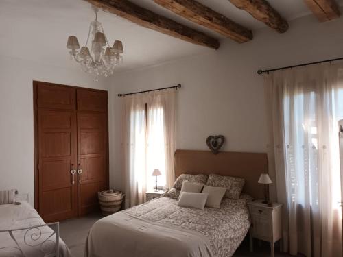 1 dormitorio con cama y lámpara de araña en Un tros de Sal. Casa Rural a Gerri de la Sal., en Gerri