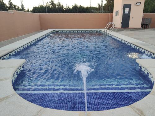 uma piscina com uma fonte de água num quintal em Casa Rural Asgard em Chiclana de la Frontera