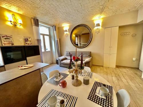 ein Wohnzimmer mit einem Tisch und einem Spiegel in der Unterkunft Chic house near the castle in Moncalieri