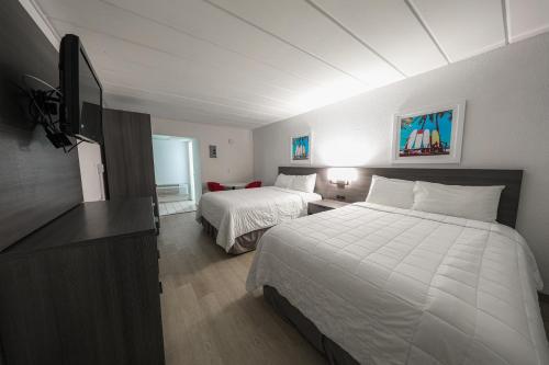 a hotel room with two beds and a flat screen tv at Flamingo Hotel & Tower in Panama City Beach