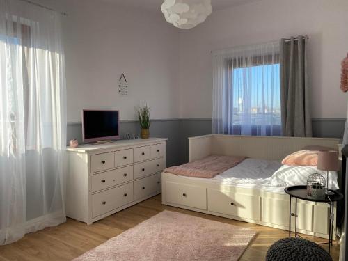 a bedroom with a bed and a television on a dresser at Apartament DeLux in Pasłęk