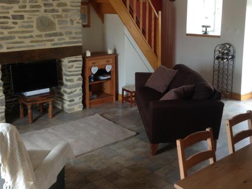 a living room with a couch and a fireplace at Le Bois Gautier in Savigny-le-Vieux