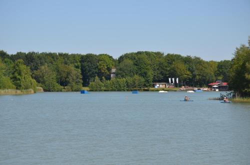 a lake with people in boats in the water at Drents Genieten - Kraaiheide met privé jacuzzi in Erm