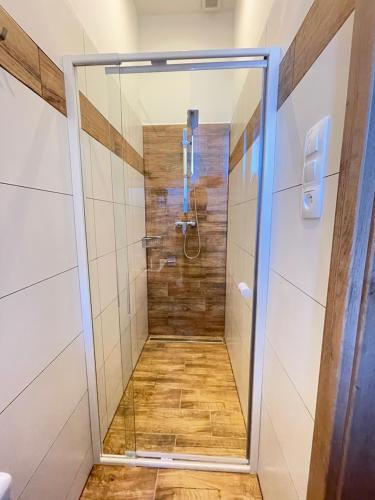 a shower with a glass door in a bathroom at Apartmán TATRAFUN in Vysoke Tatry - Tatranska Lomnica.