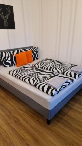 a bed with black and white sheets and orange pillows at Innenstadt-Appartement in Dresden