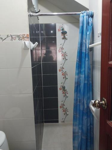 una ducha con una puerta de cristal con un pájaro en la pared en ALOJAMIENTO EDUCOL, en Moyobamba