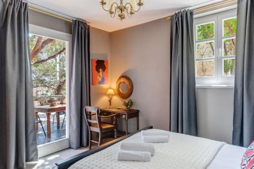 a bedroom with a bed and a desk and a table at Alma Loca Syros in Ermoupoli