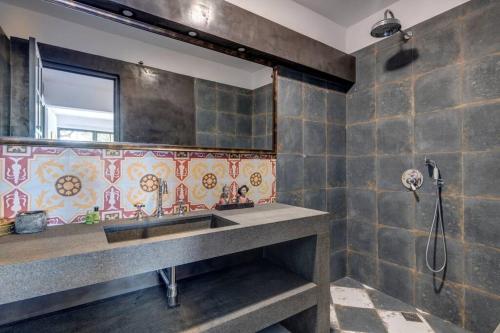 a bathroom with a sink and a shower at Alma Loca Syros in Ermoupoli