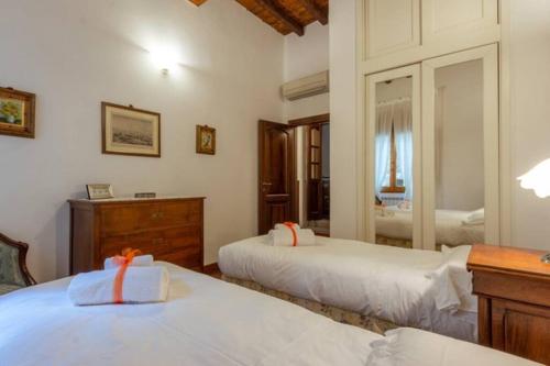 une chambre avec deux lits et un miroir dans l'établissement Ponte Vecchio - Appartamento Oltrarno Ruby, à Florence