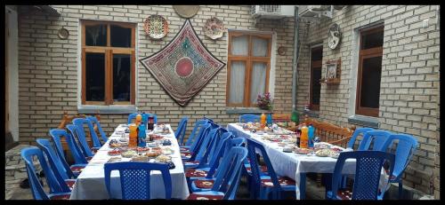 a long table with blue chairs and food on it at Masturabonu Ravshan in Bukhara