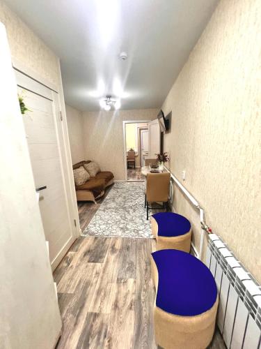 a room with two blue stools and a living room at Sport Hotel Terra in Ustʼ-Kamenogorsk