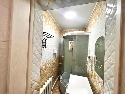 a bathroom with a toilet and a glass shower at Sport Hotel Terra in Ustʼ-Kamenogorsk