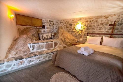 a hotel room with two beds and a stone wall at Braxos A beautiful rocky place in Hydra