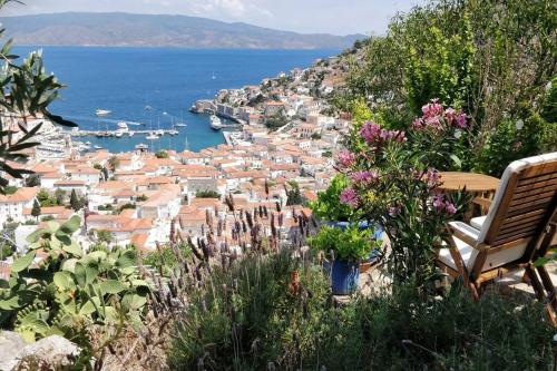 a bench sitting on a hill overlooking a city at Braxos A beautiful rocky place in Hydra