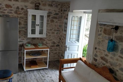a living room with a couch and a refrigerator at Braxos A beautiful rocky place in Hydra