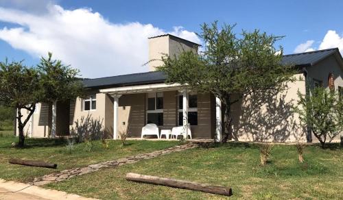 una casa con árboles delante de ella en La Pasionaria casa de sierras en Santa Rosa de Calamuchita