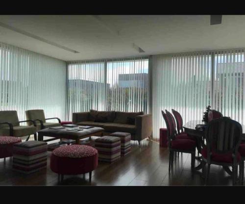 sala de estar con sofá, mesa y sillas en CASA EN COUNTRY PRIVADO RUMENCO en Mar del Plata