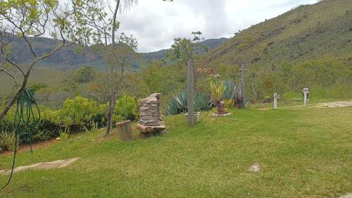 a field with a rock in the grass at Pouso do Elefante in Serra do Cipo