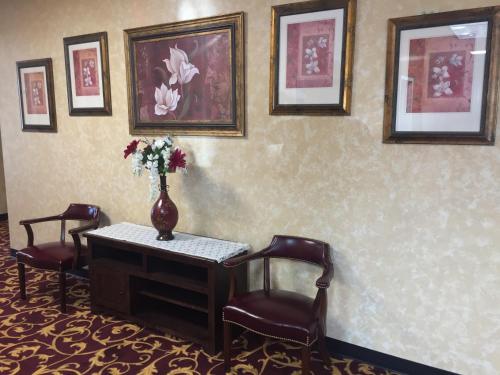 a room with a table and chairs and a vase with flowers at FairBridge Inn Express Hiawatha in Hiawatha