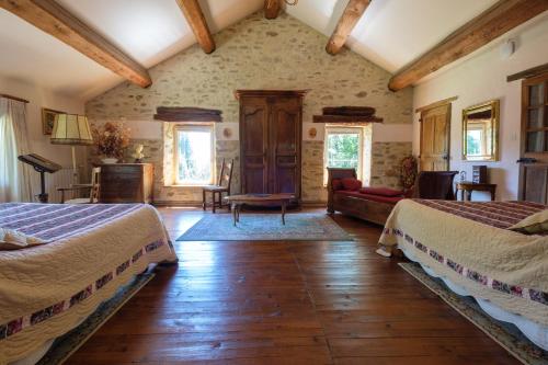een slaapkamer met 2 bedden en een woonkamer bij Domaine de Malouziès in Fontiers-Cabardès