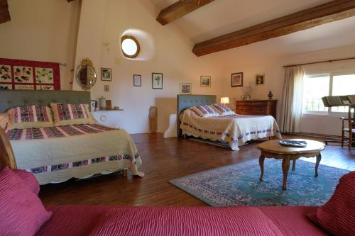 a bedroom with two beds and a table in it at Domaine de Malouziès in Fontiers-Cabardès