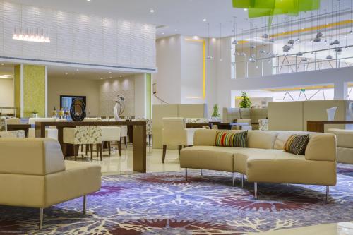 a lobby with couches and tables and a dining room at Radisson Blu Resort Jizan in Jazan